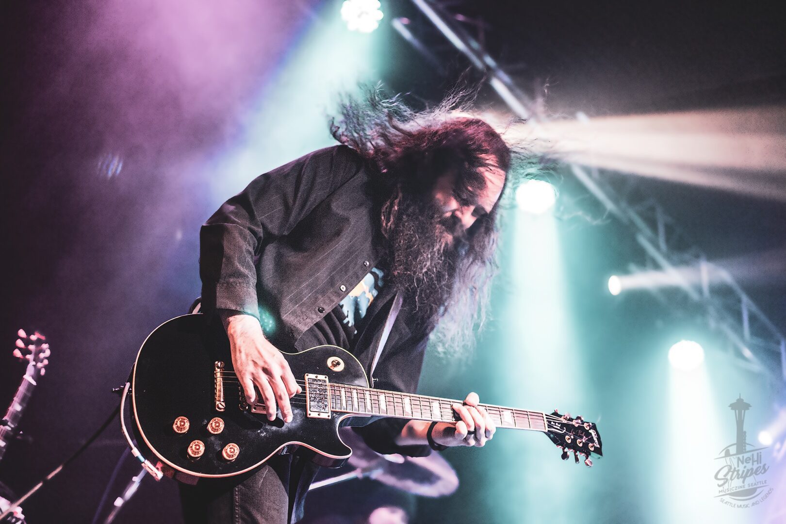 A man with long hair and beard playing guitar.