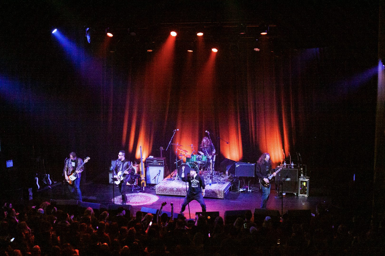 A band performing on stage with lights in the background.